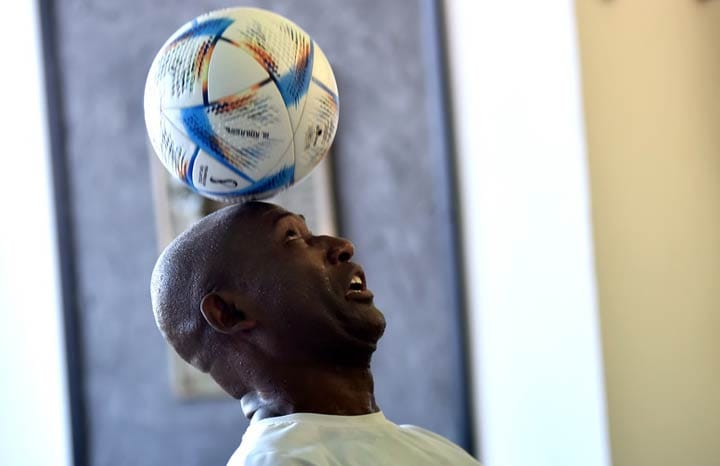 Hombre equilibrando balón de fútbol en la cabeza