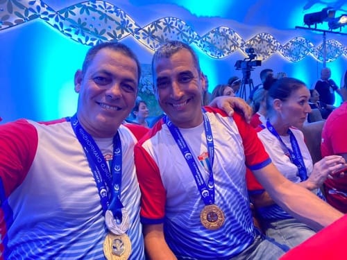 Dos hombres sonrientes con medallas al cuello