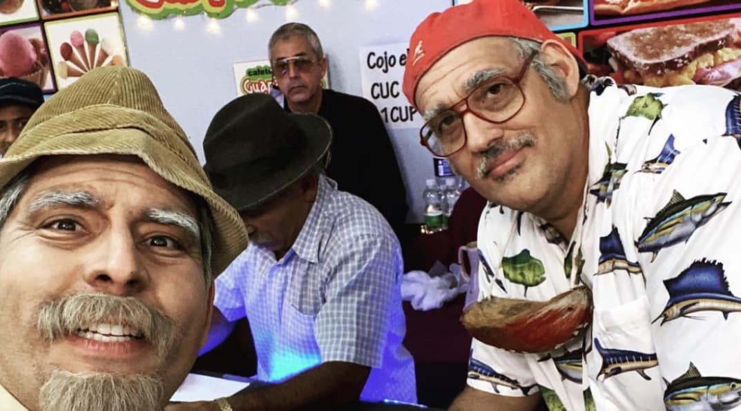 Dos hombres sonrientes con sombreros en evento