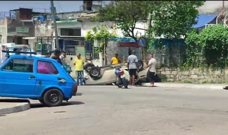 Gente ayudando en accidente de coche volcado