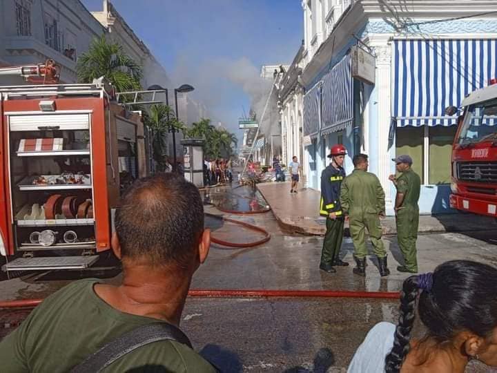 Bomberos controlando incendio en calle urbana