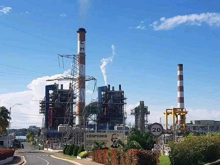 Planta industrial emitiendo humo bajo cielo azul