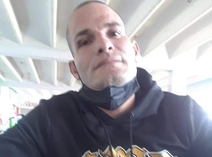 Hombre con sudadera negra y mascarilla bajada