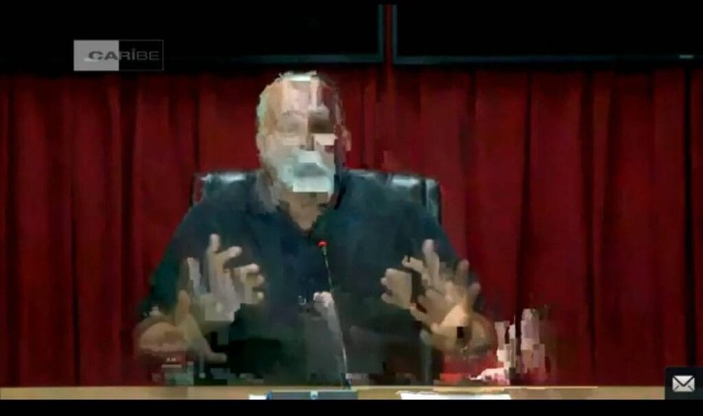 Hombre gesticulando en conferencia con fondo rojo