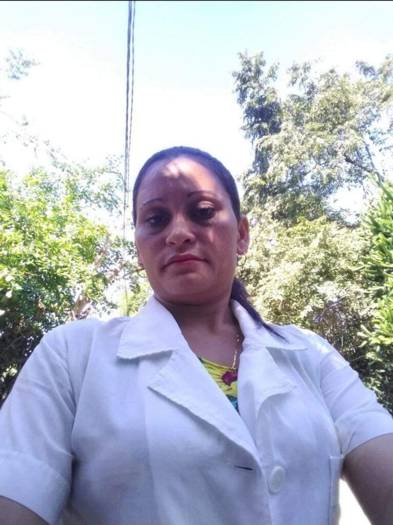 Mujer en bata blanca frente a árboles