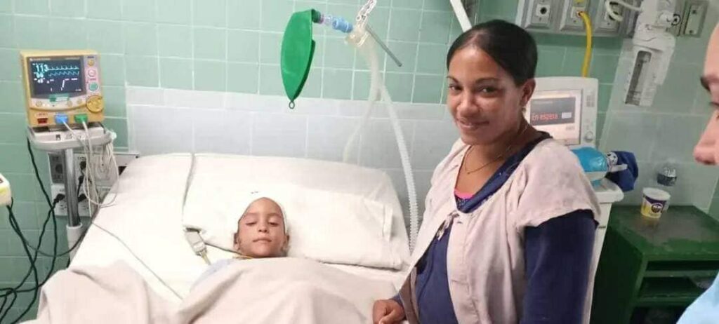 Niño hospitalizado y mujer sonriente junto a él