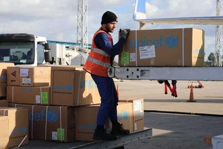 Trabajador descarga cajas de UNICEF en aeropuerto