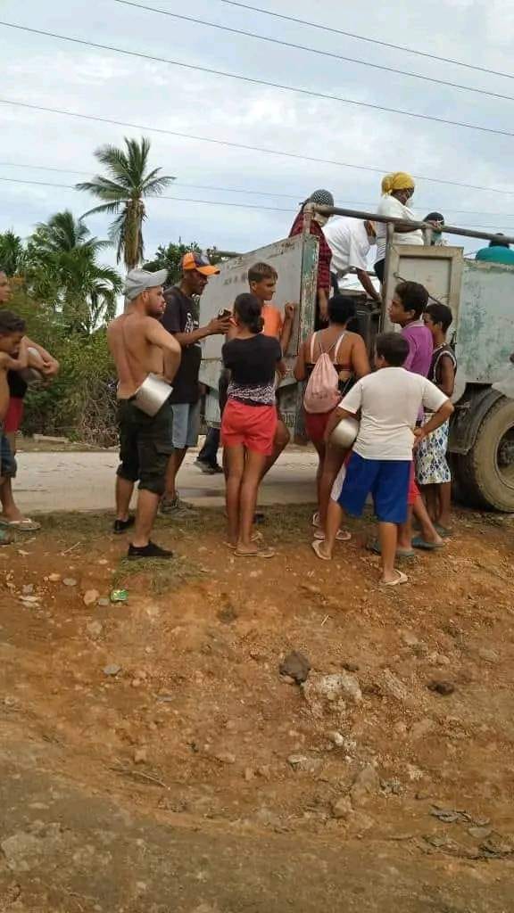 Personas recibiendo suministros de camión en zona rural