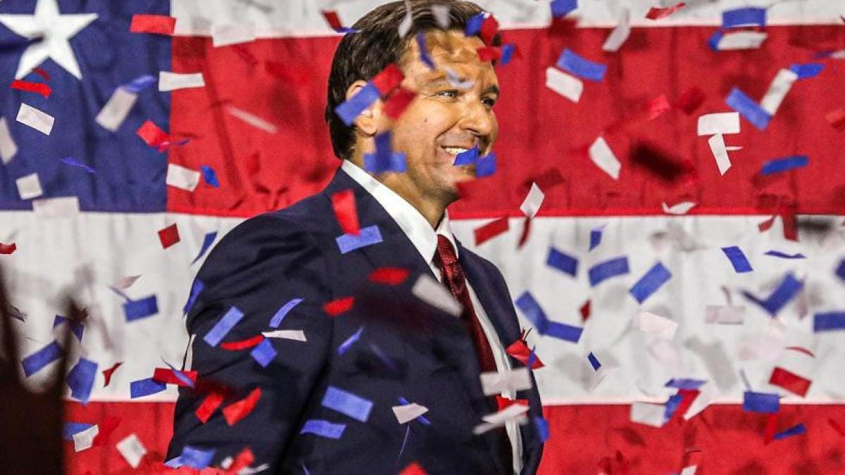 Hombre sonriente con confeti y bandera estadounidense