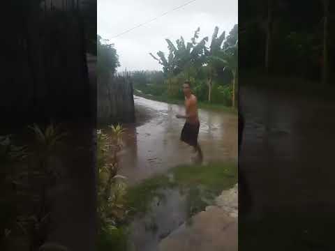Persona corriendo bajo lluvia en camino rural