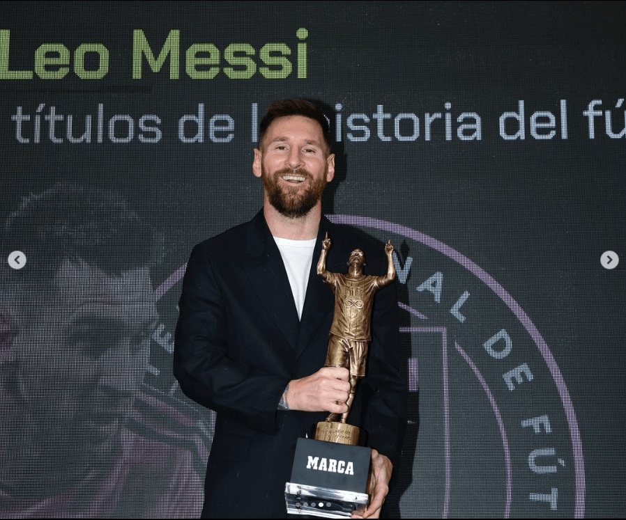 Hombre sonriente sosteniendo trofeo en evento deportivo