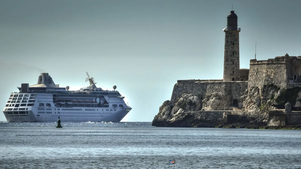 Crucero grande cerca de faro histórico en mar