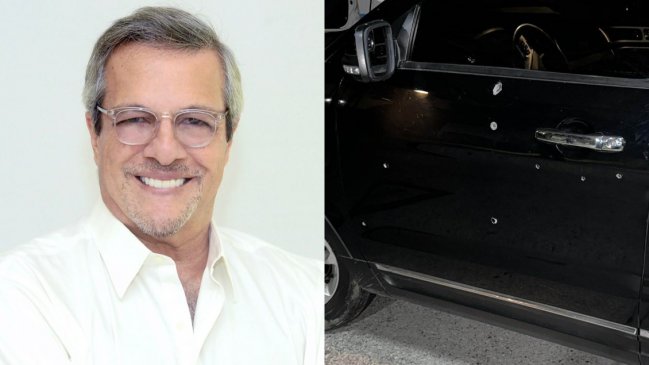 Hombre sonriente con gafas y coche negro