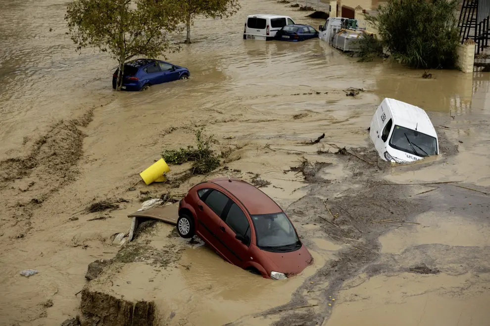 Coches sumergidos en inundación con lodo