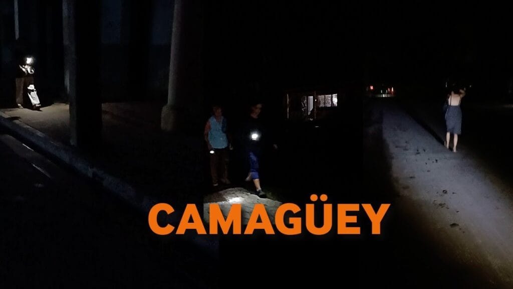 Personas con linternas en calle oscura en Camagüey.