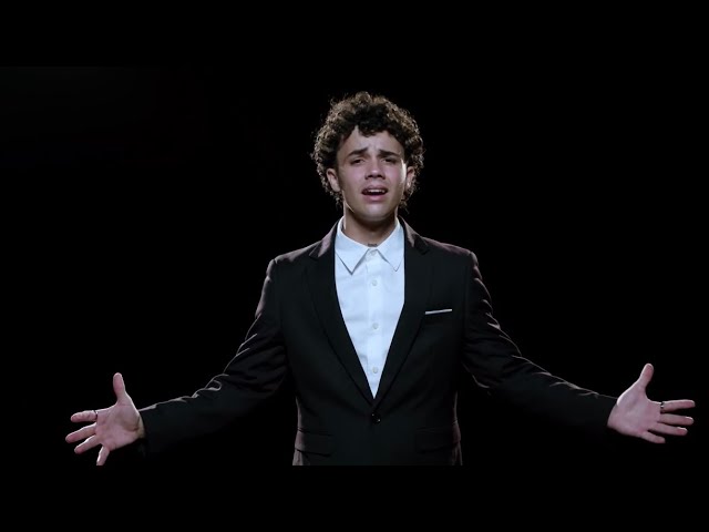 Joven cantando emocionado en fondo negro