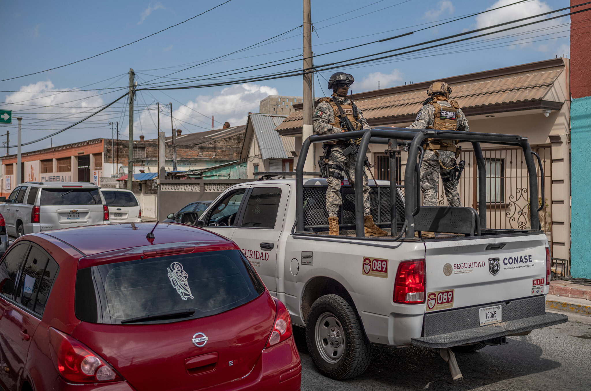 Soldados vigilando desde camioneta en calle urbana