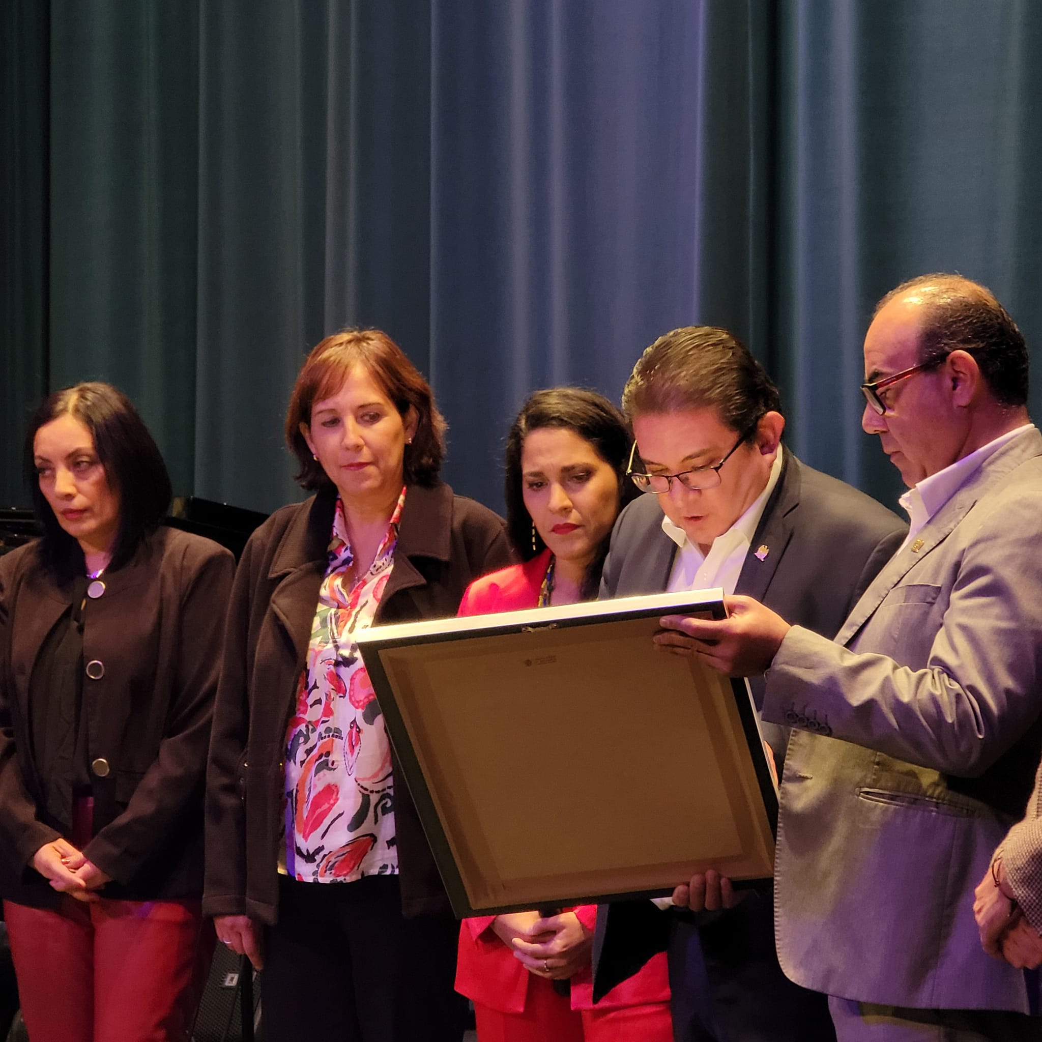 Grupo de personas examina documento en evento formal