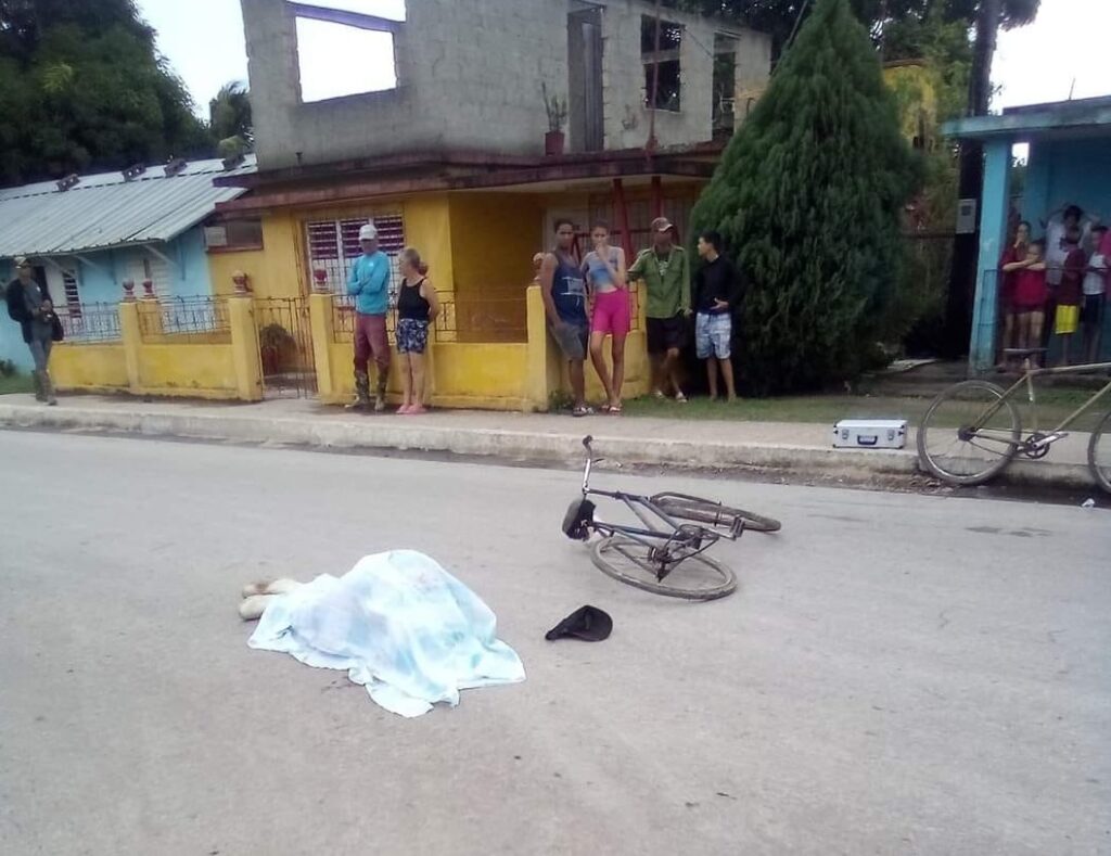 Personas observando bicicleta caída en calle urbana