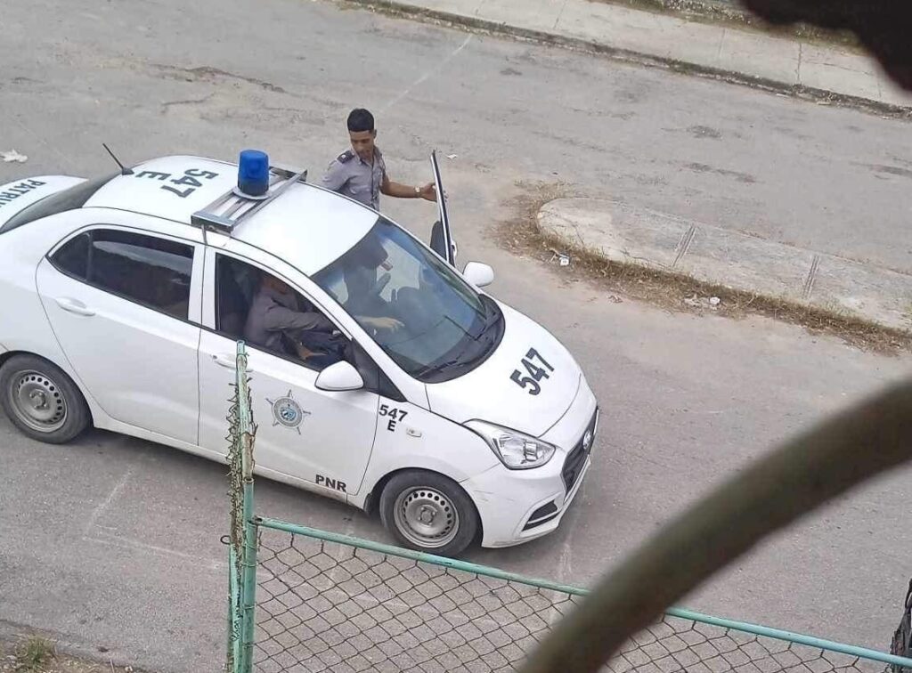 Policía saliendo de coche patrulla numerado