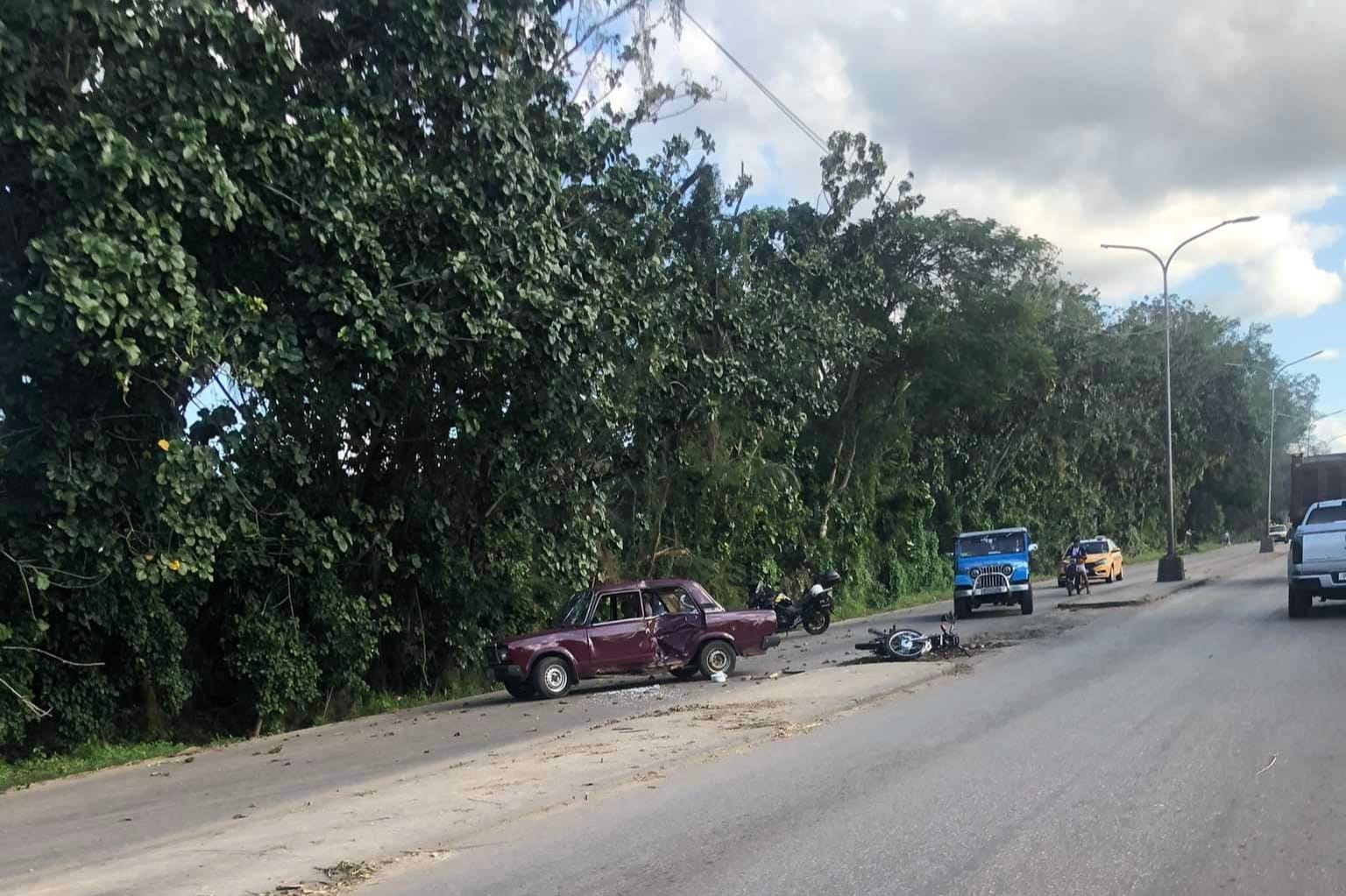 Coche viejo accidentado al lado de carretera arbolada