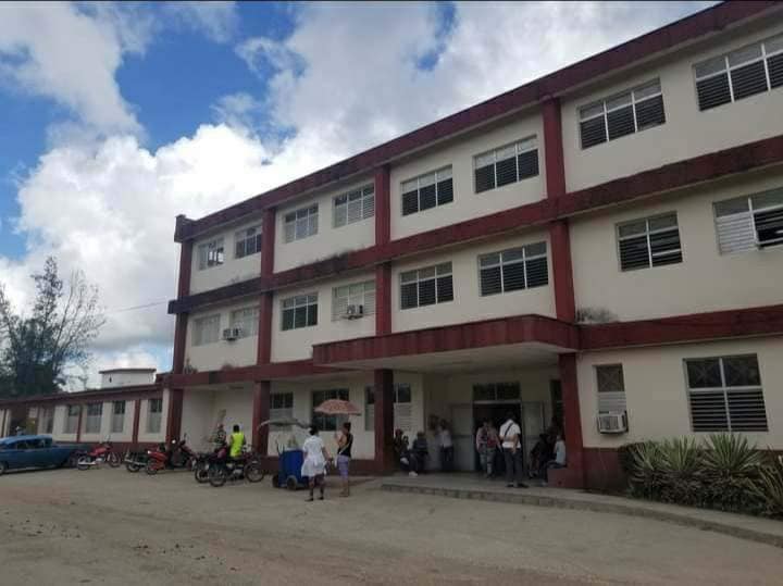 Edificio grande con personas y motos afuera
