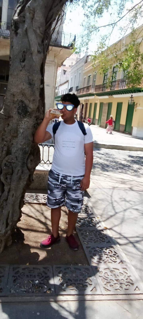 Hombre bebiendo agua en calle soleada