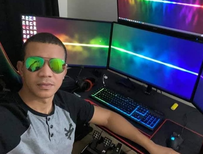 Hombre con gafas ante múltiples monitores iluminados