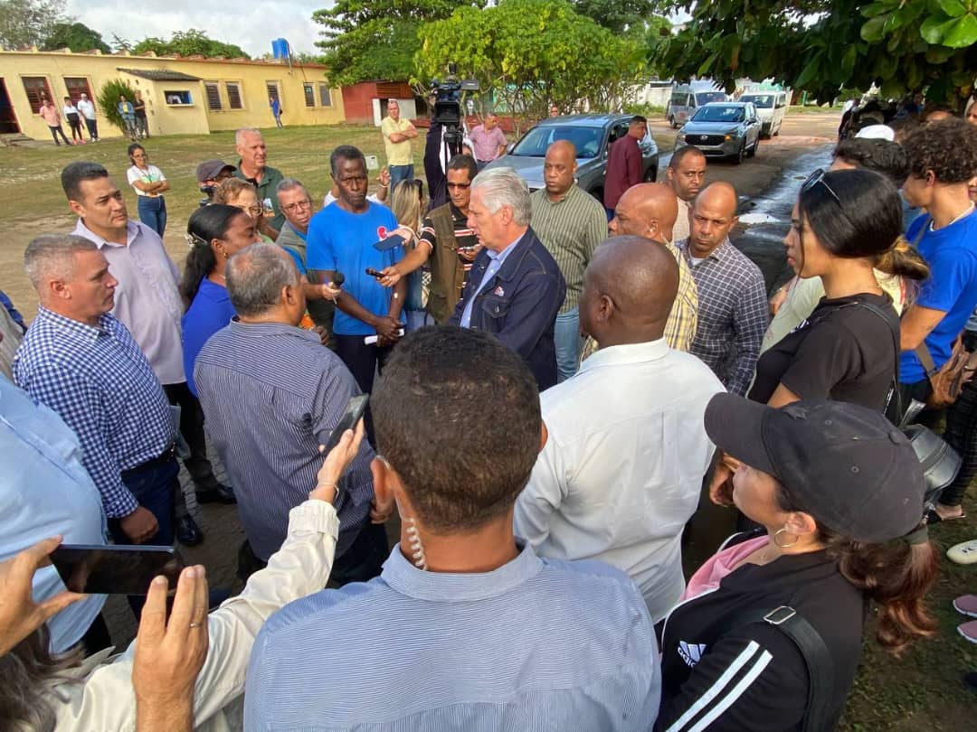 Grupo grande reuniéndose al aire libre con hombre canoso