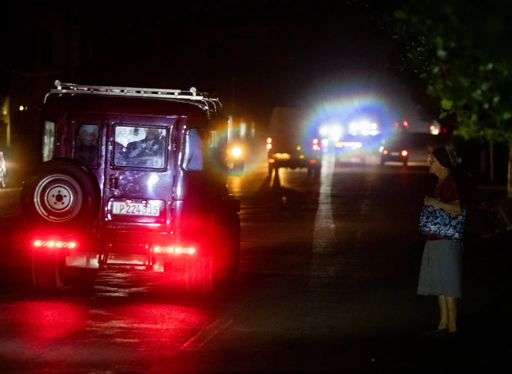 Mujer observa jeep iluminado por la noche