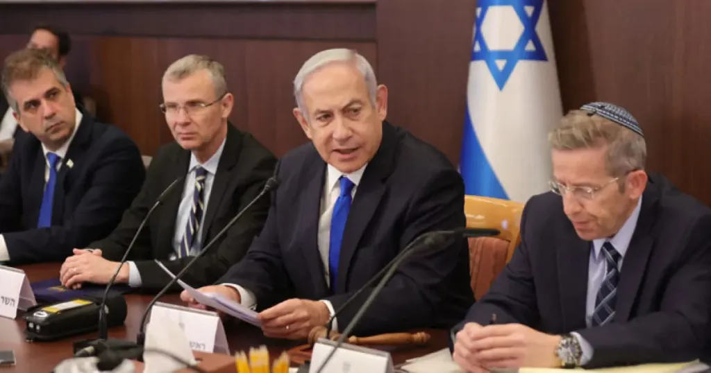 Funcionarios reunidos con bandera de Israel