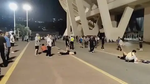 Personas reunidas de noche fuera de estadio