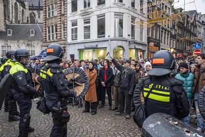 Policía antidisturbios frente a manifestantes en ciudad
