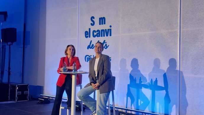 Dos presentadores en conferencia con público sombreado