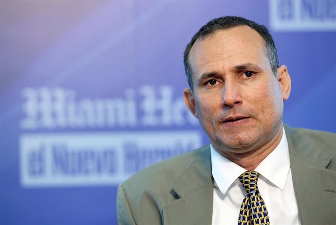 Hombre serio en conferencia con fondo de logotipo