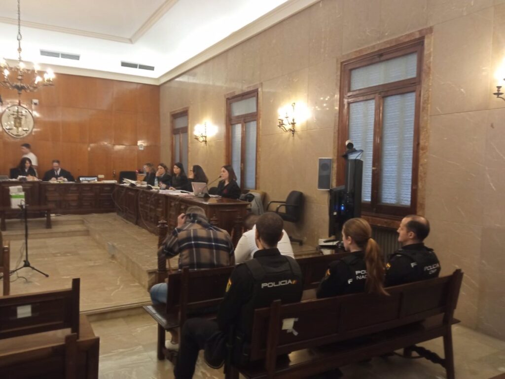 Sala de juicio con jueces, policías y público