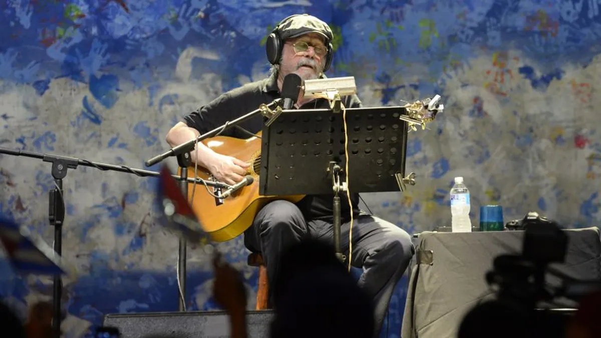 Hombre mayor tocando guitarra en concierto
