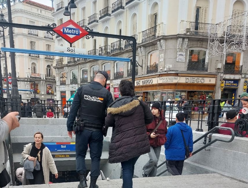 Policía y transeúntes en entrada metro Sol, Madrid