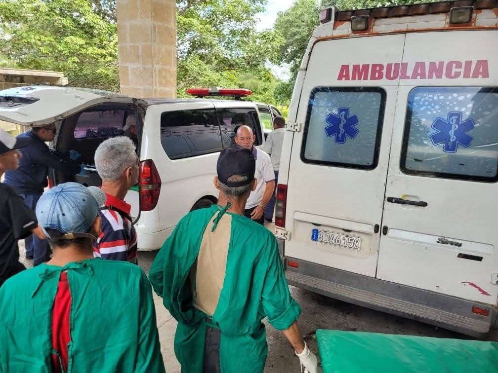 Personas cargando paciente en ambulancia