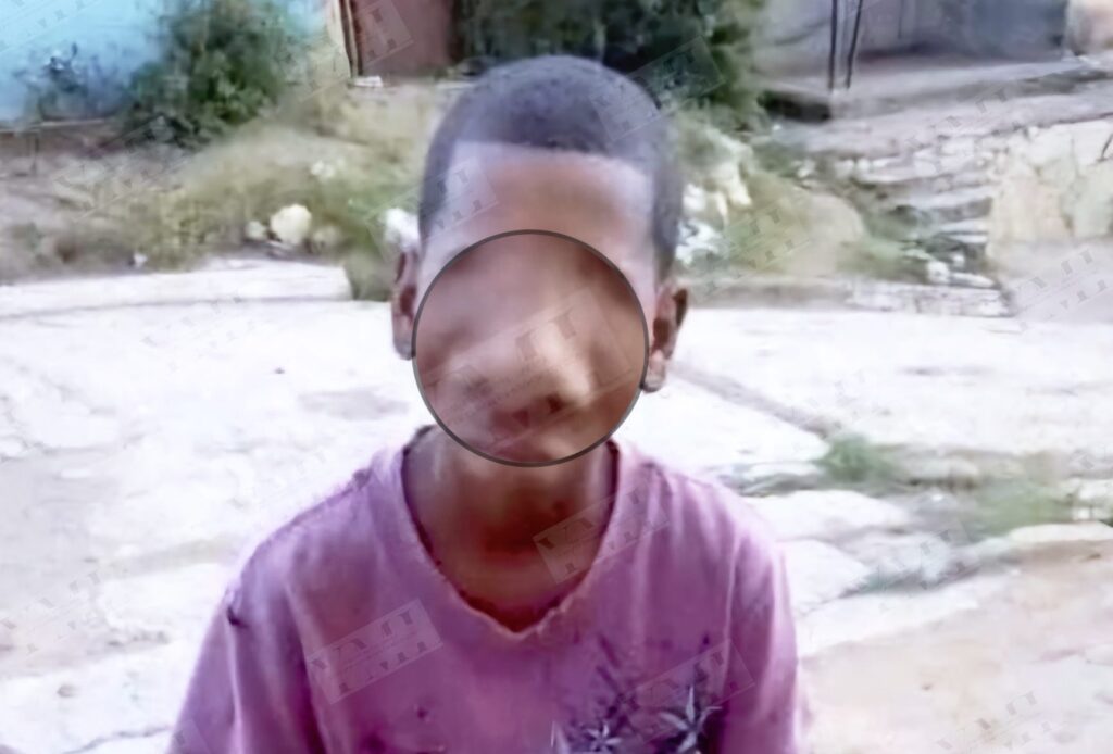 Niño con camiseta rosa en entorno rural