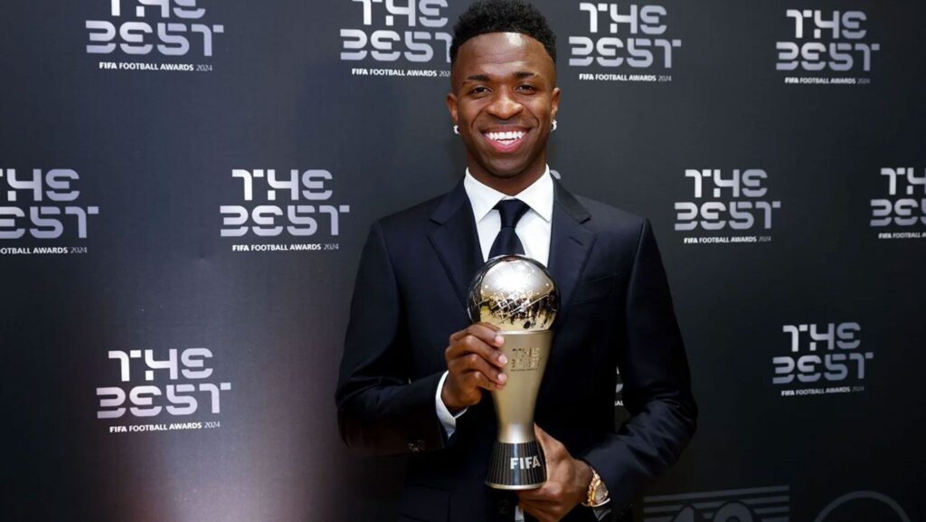 Futbolista sonriente sostiene trofeo FIFA The Best