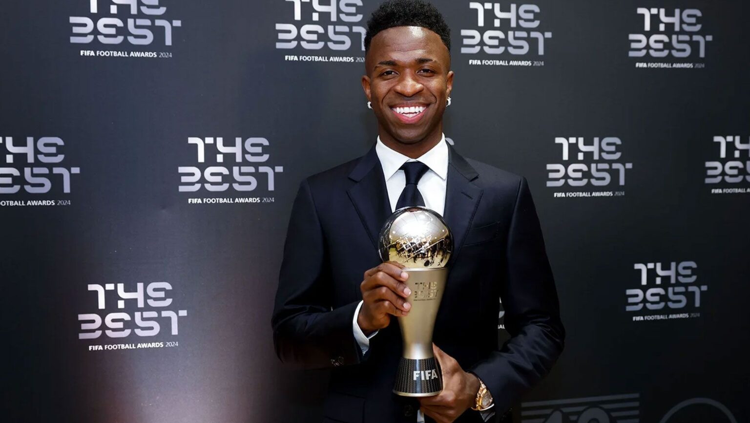 Futbolista sonriente sostiene trofeo FIFA The Best