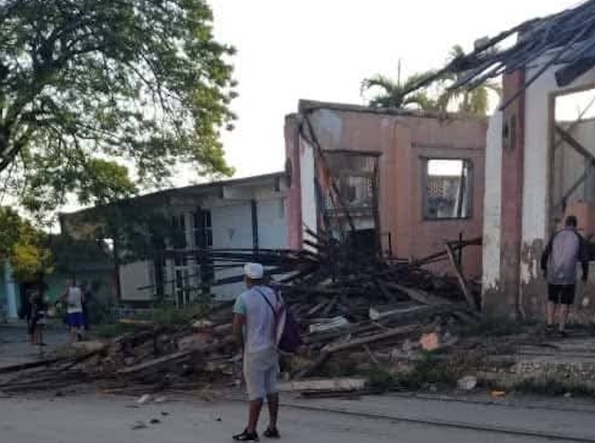 Edificio derruido con escombros y personas observando