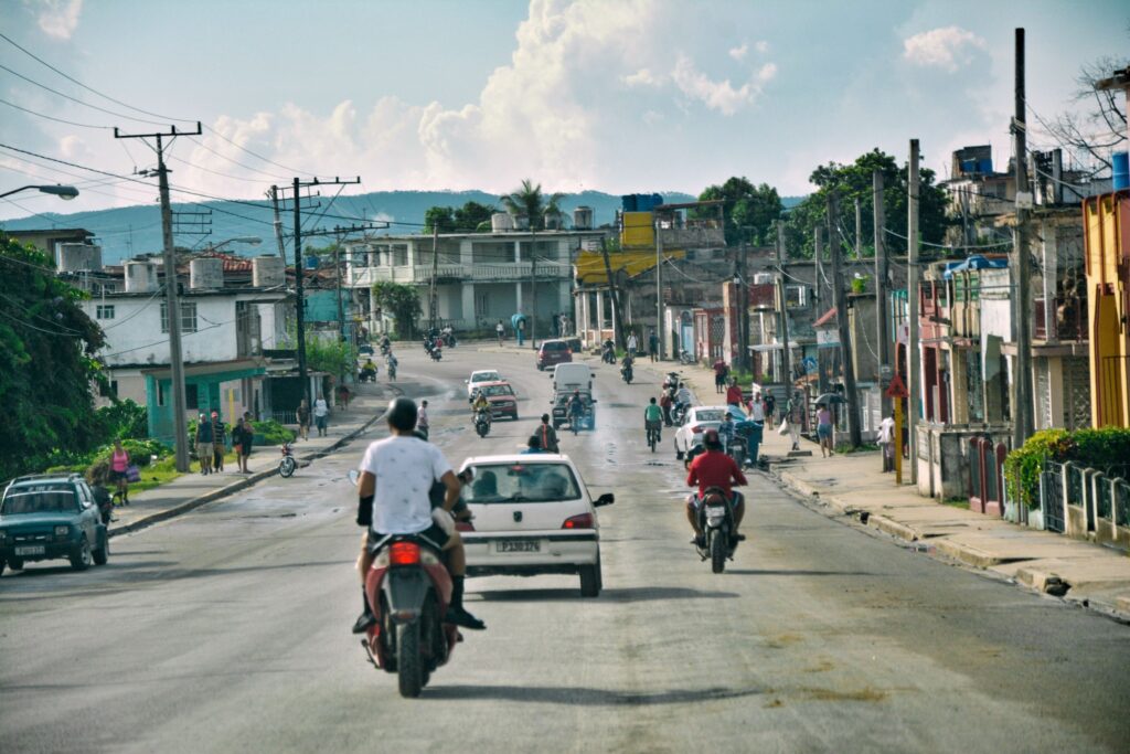 Calle bulliciosa en ciudad tropical con vehículos y peatones