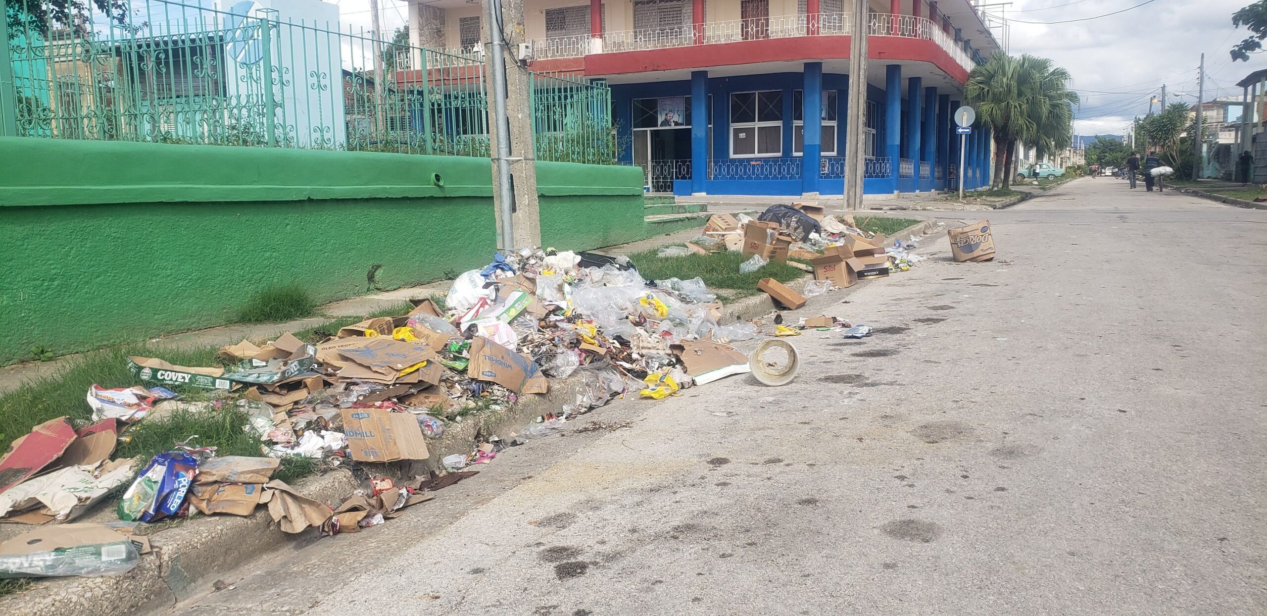 Calle con basura acumulada junto a edificios coloridos
