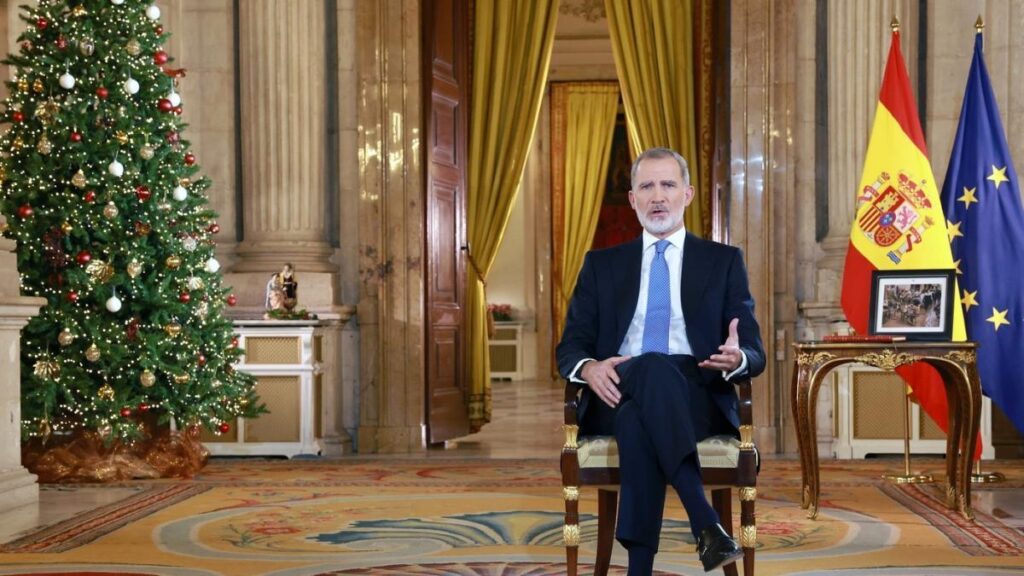 Hombre hablando, árbol de Navidad y banderas