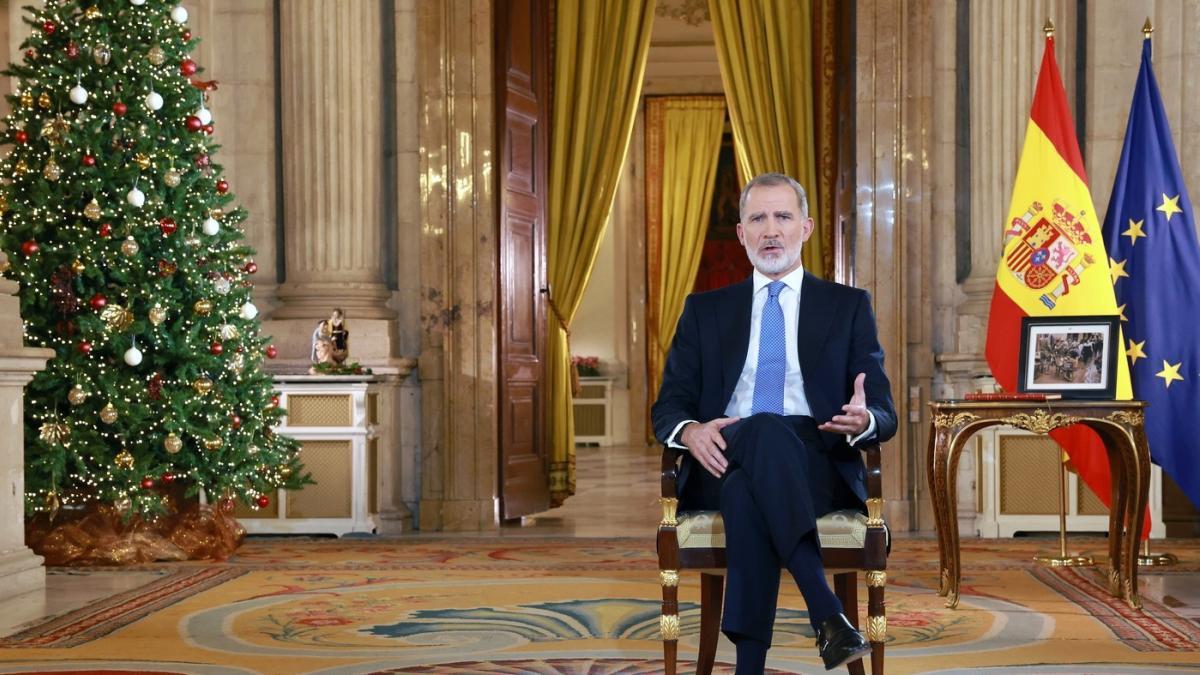 Hombre hablando, árbol de Navidad y banderas