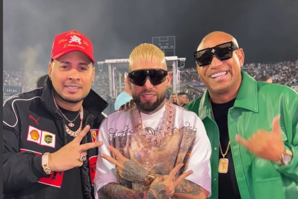 Tres hombres sonriendo en un estadio