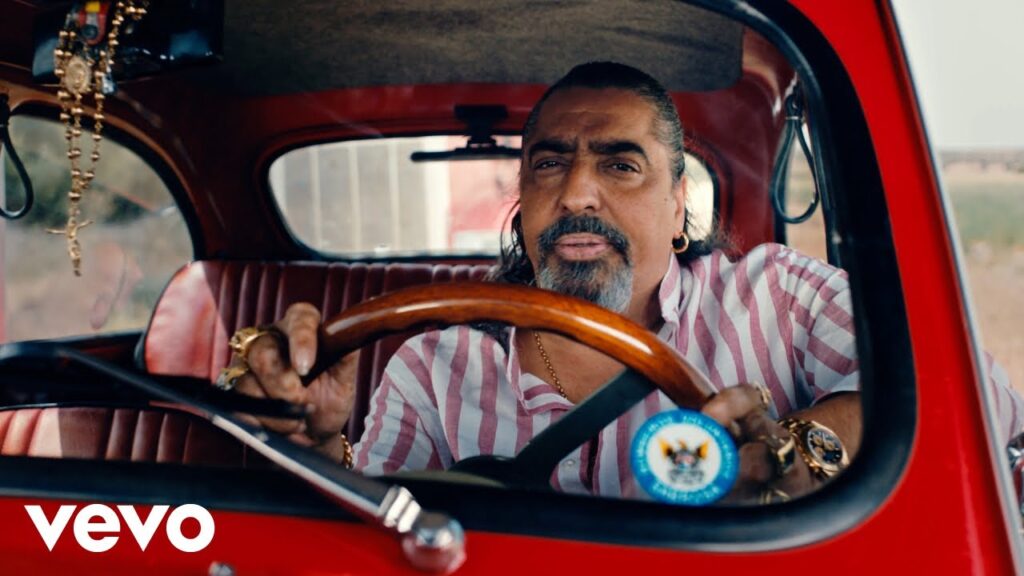 Hombre conduciendo coche rojo antiguo