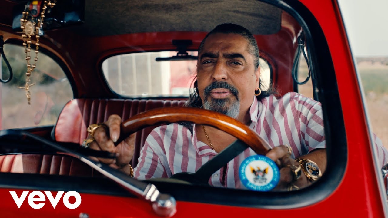 Hombre conduciendo coche rojo antiguo